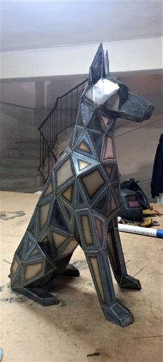 a dog statue sitting on top of a wooden floor