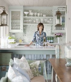 a woman standing at the counter in a kitchen