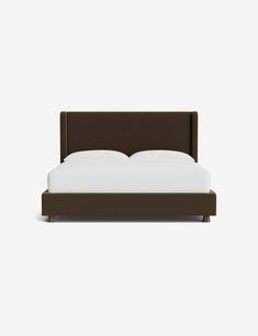 a bed with a brown headboard and white sheets