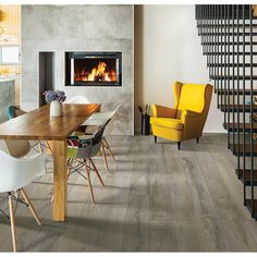 a dining room table with chairs and a fire place in the background