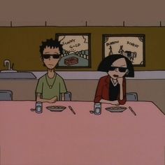 two people sitting at a table with food in front of them and one person wearing sunglasses