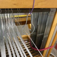 a close up of a weaving machine with some yarn on the table next to it