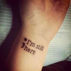 a small wrist tattoo with the words i'm still here written in cursive font