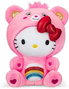 a pink hello kitty stuffed animal with a red bow on it's head sitting next to a rainbow