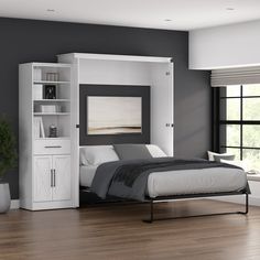 a white bed sitting next to a book shelf on top of a hard wood floor