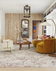 a living room filled with furniture and bookshelves next to a doorway that leads to another room