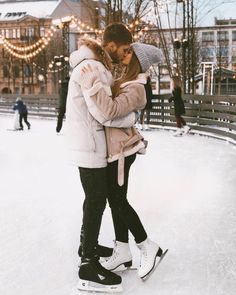 two people standing in the snow hugging each other