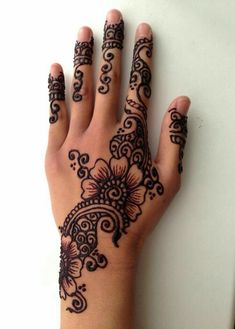 a woman's hand with henna tattoos on it