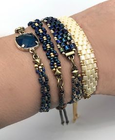 a woman's arm with three bracelets on it and a blue stone in the middle