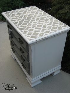 a white and gray dresser sitting on top of a sidewalk