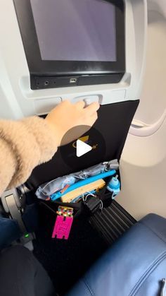 someone is sitting in an airplane with their feet up on the seat and holding a laptop