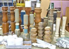 many different types and sizes of candles on a table