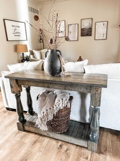 a living room with a couch, table and pictures on the wall