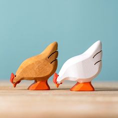 two wooden toy birds standing next to each other