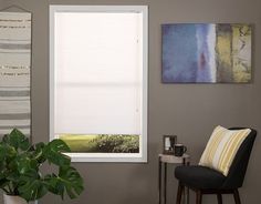 a living room with a chair, window and painting on the wall above it's windowsill