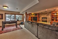 a living room with couches and a fireplace in the corner next to a large window