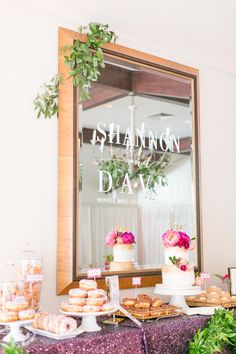 a table topped with cakes and desserts next to a mirror