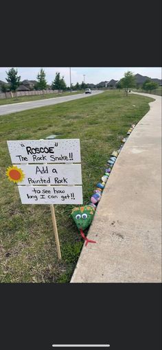 a sign that has been placed on the side of a road in front of some grass