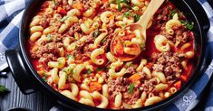 a skillet filled with pasta, meat and vegetables