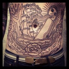 a man's stomach with tattoos on it and an image of a ship in the middle