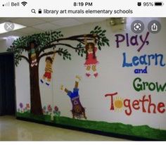 a classroom wall painted with children's pictures and words that read, play learn and grow together