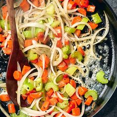 a skillet filled with onions, carrots and celery