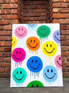 a colorful painting on a brick wall with smiley faces painted in different colors and shapes