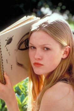 a young woman holding an open book in her hands