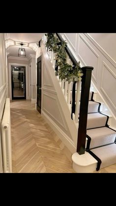 the stairs are decorated with wreaths and greenery for holiday decor in this home