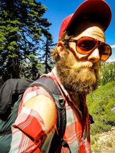 a man with a beard wearing sunglasses and a backpack