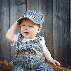 a small child wearing a hat and overalls