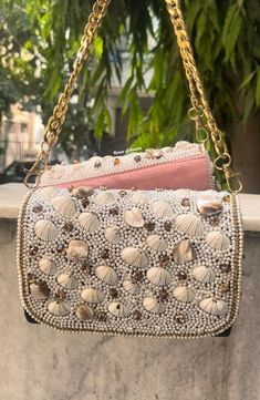 This is a beautiful handcrafted flap bag made with love.It has intricate handwork which showcases the Indian craftsmanship by our local artisans. It comes with a matching handwork handle Details  - Single side handwork  - Fabric lining on the inside to keep your belongings safe  - Magnetic lock closure  - Detachable handle This clutch can be worn as a crossbody bag or a shoulder bag with the sling chain or can simply be carried in hand.It is spacious enough to carry mobile phones, lipsticks, Key Asian Gifts, Indian Gifts, Embroidered Clutch, Wedding Clutch, Wedding Accessory, Indian Embroidery, Luxury Bag, Bride Gift, Bag Luxury