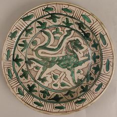 a green and white plate with an animal on it's side, in the shape of a lion