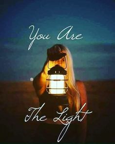 a woman holding a lantern with the words you are the light