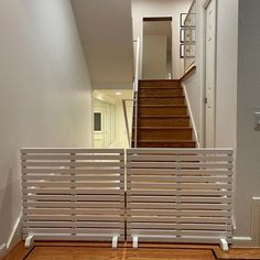 an empty hallway with wooden floors and white railing