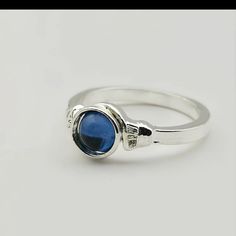 a silver ring with a blue stone on it