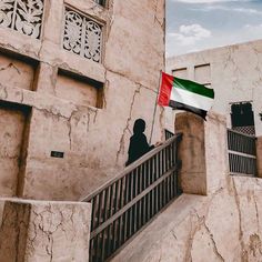 a person standing on a balcony with a flag