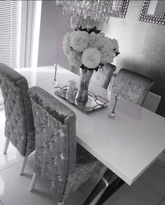 a dining room table with chairs and a vase filled with flowers