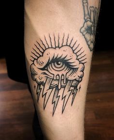 a man's leg with an all seeing eye and lightning bolt tattoo on it