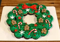 cupcakes decorated with green frosting and candy canes in the shape of a wreath