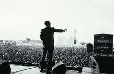 a man standing on top of a stage in front of a large group of people