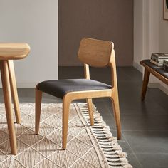 two wooden chairs sitting next to each other on top of a rug