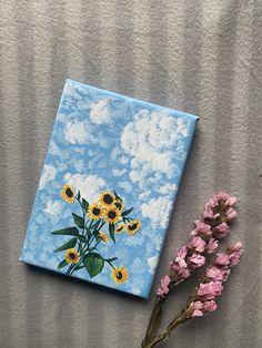 a painting of sunflowers on a blue sky with white clouds and pink flowers