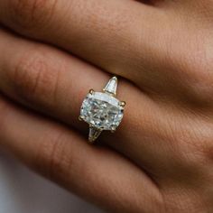 a woman's hand with a diamond ring on it