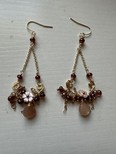 Peach moonstone gold plated earrings with Hessonite Garnet and hand carved mother of pearl flowers. Bohemian Gold Mother Of Pearl Earrings, Elegant Brown Drop Flower Earrings, Elegant Brown Mother Of Pearl Jewelry, Elegant Brown Flower Earrings For Pierced Ears, Elegant Brown Flower Earrings For Gift, Gold Flower Jewelry With Natural Stones, Earth Tone Jewelry, Victorian Style Earrings, Pearl Flowers