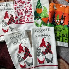 six hand towels with gnomes on them are sitting on a bed and one towel has the words gnome holidays printed on it