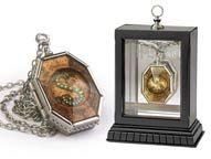 two necklaces with different designs on them, one is in a glass case and the other has a clock inside