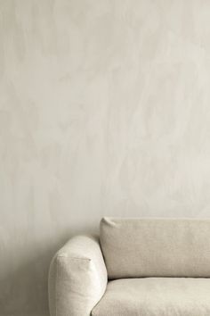 a white couch sitting in front of a wall