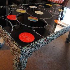 a table with vinyl records on it in the middle of a living room filled with furniture