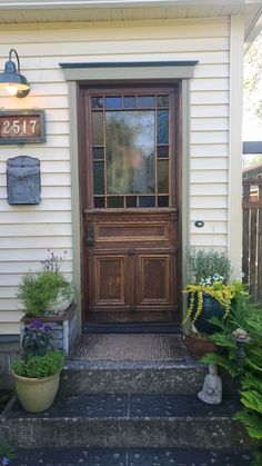 the front door of a house with potted plants